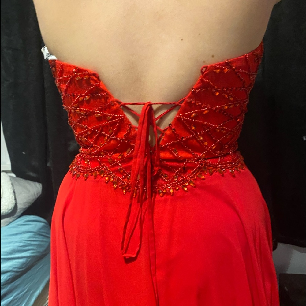Tie back strapless red prom dress has slit in leg